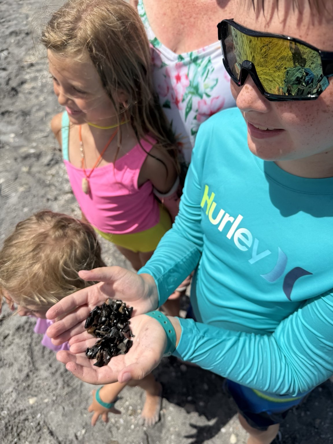 Guest showing a handful of shark teeth found on the beach